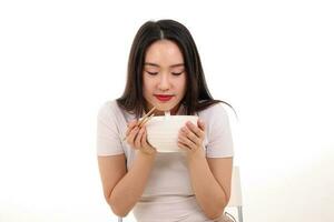 mooi jong zuiden oosten- Aziatisch vrouw Holding Chinese leeg eetstokje soep lepel kom werktuig doen alsof acteren poseren zien eten smaak geur voeden aanbod tevredenheid lekker wit achtergrond gelukkig foto