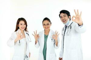 Aziatisch Maleis Chinese mannetje vrouw drie artsen OK hand- zingen naar camera Aan wit achtergrond foto