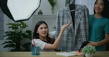 jong mooi Aziatisch vrouw leven streaming Bij kleren winkel foto