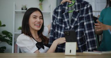jong mooi Aziatisch vrouw leven streaming Bij kleren winkel Aan digitaal camera foto