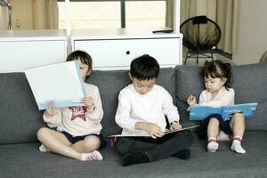 kind familie vader moeder dochter zoon zitten Aan sofa lezing schrijven studie onderwijs foto