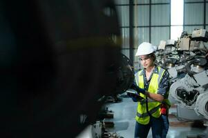 een vrouw ingenieur installeert een programma Aan een robotica arm in een robot magazijn. en test de operatie voordat Bezig met verzenden de machine naar de klant. foto