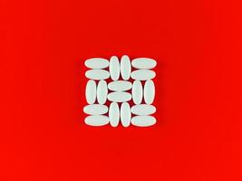 vierkante vorm gemaakt van witte tabletten op rode achtergrond