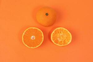 mandarijn- oranje fruit plak voor de helft geperst geëxtraheerd Aan oranje achtergrond foto