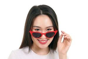 mooi jong zuiden oosten- Aziatisch vrouw pieken over- vervelend rood kader donker zonnebril houding mode stijl wit achtergrond glimlach gelukkig foto