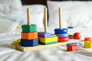 houten kleurrijke blokken en sorteervormen op het bed foto