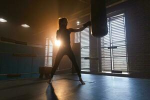 Dames zelf verdediging meisje stroom. sterk vrouw vechter opleiding stoten Aan boksen ring. gezond sterk meisje ponsen boksen tas. opleiding dag in boksen Sportschool. sterkte fit lichaam training opleiding. foto