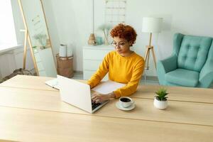 Afrikaanse Amerikaans meisje gebruik makend van laptop Bij huis kantoor op zoek Bij scherm typen chatten lezing schrijven e-mail. jong vrouw hebben virtueel vergadering online babbelen video telefoontje conferentie werk aan het leren van huis foto