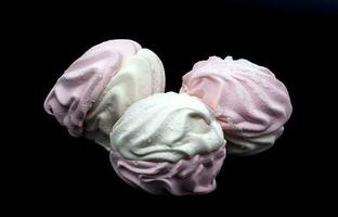 wit en roze gecanneleerd marshmallows Aan een zwart achtergrond. geheel en gebroken uit deel. onderwerpen foto. foto in hoog kwaliteit. horizontaal