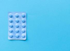 een blister met blauwe pillen op blauwe achtergrond monochroom eenvoudig plat leggen met pastel textuur met kopie ruimte medische concept stock foto