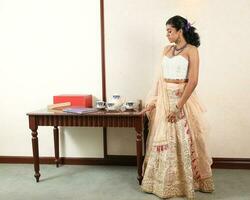 mooi jong vrouw vervelend modern Indisch Lehenga hgagra enkel lengte rok jurk poseren huis retro wijnoogst foto