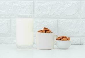melk amandelen in een glas Aan een wit achtergrond foto