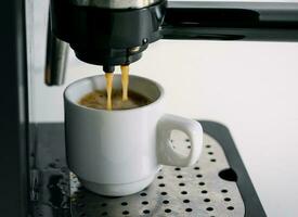 koffie machine extractie in een koffie kop foto