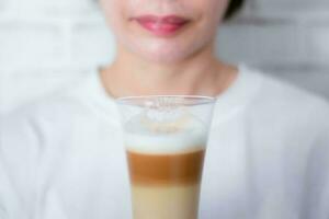 vrouw Holding een kop koffie latte melk schuim de heet drinken foto