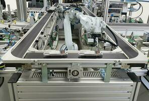 geautomatiseerd robot armen Aan transportband riemen in de fabriek industrie foto