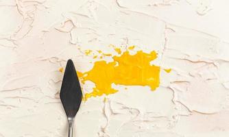 een schilderij paletmes geïsoleerd op een crème geschilderde achtergrond schilderij geel met kopie ruimte