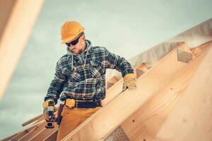 houten huis dak skelet kader bijeenkomst door professioneel bouw arbeider foto