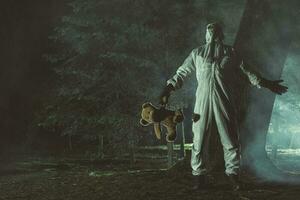 gefrustreerd mannen in Hazmat pak en biohazard masker houden teddy beer foto