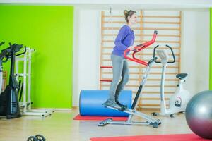 vrouw oefenen Aan elliptisch machine foto