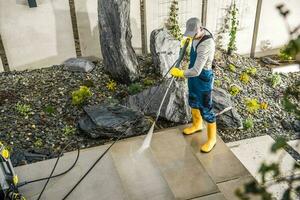 arbeider schoonmaak de werf in de omgeving van de huis foto