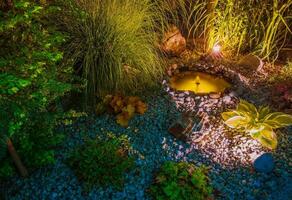 verlichte tuin met vijver foto