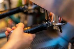 barista handen maken van koffie uit de machine foto