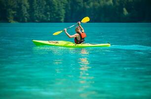 kayaker in een toeren kajak Aan de toneel- meer foto