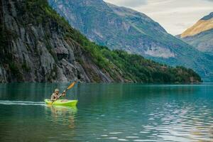 mannen in een kajak Aan glaciaal meer in de Noorwegen foto