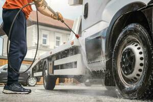 arbeider macht het wassen zijn slepen vrachtauto foto