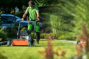 tuinarchitect met verticuteermachine machine nemen zorg van een gazon. foto