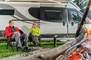 paar drinken wijn in voorkant van hun rv camper busje foto