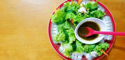 garnaal salade beet recepten met pittig of verzuren saus in wit, rood schotel en en lepel Aan houten tafel of achtergrond met links kopiëren ruimte Bij Vietnamees restaurant.gezond aan het eten leven stijl en Aziatisch voedsel foto