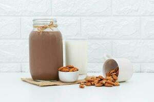 melk chocola en amandelen in een glas Aan een wit achtergrond foto