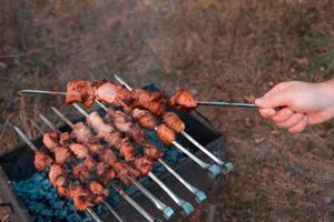 man frituren shish kebab op de grill foto