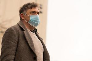 ziekte-uitbraak coronavirus pandemie portret van een man die zijn gezicht bedekt met een medisch masker om zijn neus en mond te beschermen foto