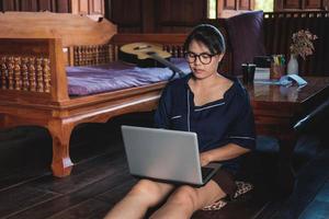 jonge vrouw werken zittend op de bank met laptop thuis foto