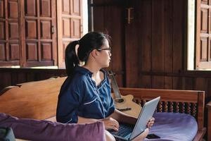 jonge vrouw werken zittend op de bank met laptop thuis foto