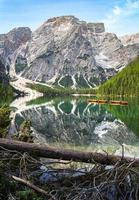 Hoge hoekmening van boten met mount seekofel spiegelen in het heldere kalme water van iconische pragser wildsee lago di braies in de Dolomieten foto