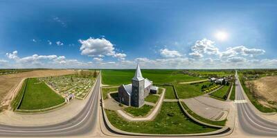 vol hdri 360 panorama antenne visie van nordic neo gotisch Katholiek kerk in platteland in de buurt begraafplaats in equirectangular projectie met zenit en nadir. vr ar inhoud foto