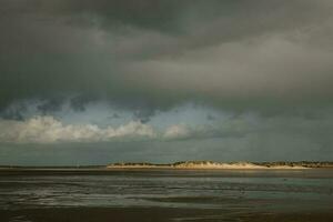 verlicht zand duinen Aan horizon Aan de kustlijn van de noorden zee Aan de Denemarken romo eiland gedurende de laag tij foto