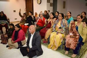 nieuw Delhi, Indië, mei 31 2023 - groep yoga oefening klasse voor mensen van verschillend leeftijd in yoga instituut, Internationale yoga dag, groot groep van volwassenen Bijwonen een yoga klasse Bij yoga kunst van leven centrum foto