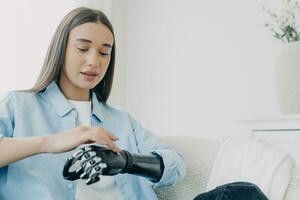 gehandicapt meisje onderzoekt haar bionische arm en drukt op knoppen. futuristische technologie. foto