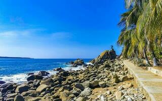 surfer golven turkoois blauw water rotsen kliffen keien puerto escondido. foto