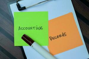 concept van accounting records schrijven Aan kleverig aantekeningen geïsoleerd Aan houten tafel. foto