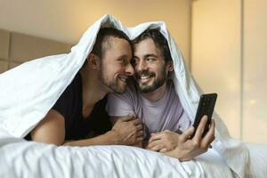 gelukkig homo paar hebben inschrijving momenten in slaapkamer - homoseksueel liefde verhouding en geslacht gelijkheid concept foto