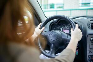 mooi glimlachen jong roodharige vrouw achter stuurinrichting wiel het rijden auto. foto