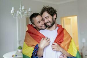 aanhankelijk mannetje homo paar binnenshuis. Mens omarmen zijn vriendje van achter Bij huis. homo paar vieren trots maand foto