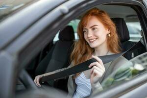 jong vrouw zittend Aan auto stoel en bevestiging stoel riem, auto veiligheid concept. vrouw vastmaakt een stoel riem in de auto. Kaukasisch vrouw bestuurder bevestiging auto stoel riem terwijl zittend achter de wiel auto. foto