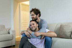 portret van zorgeloos homo paar binnenshuis. gelukkig homo paar uitgeven tijd samen foto