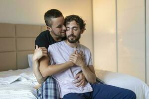 gelukkig homo paar aan het liegen naar beneden Aan de bed Bij huis, knuffelen en flirten. lgbt homo paar liefde momenten geluk concept foto